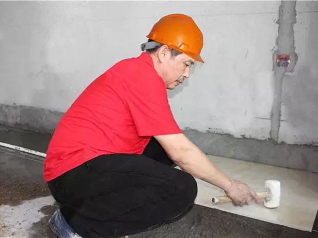 5鋪貼地磚時，磚的背面朝上批刮水泥油，并按箭頭所指方向統(tǒng)一鋪貼，用橡皮錘從中到邊，由重到輕敲實.jpg